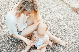 woman and a baby sitting on the ground