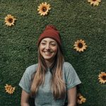 smiling woman leaning on floral wall