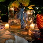 a table topped with lots of glasses and candles