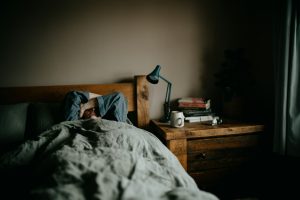 a person laying in bed under a blanket