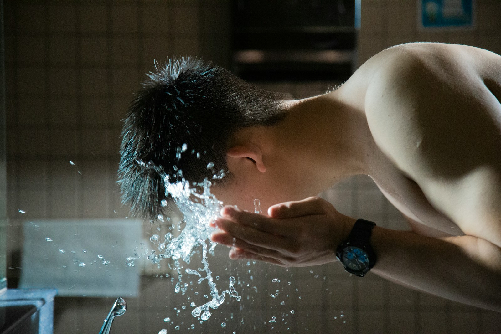 person washing face with water